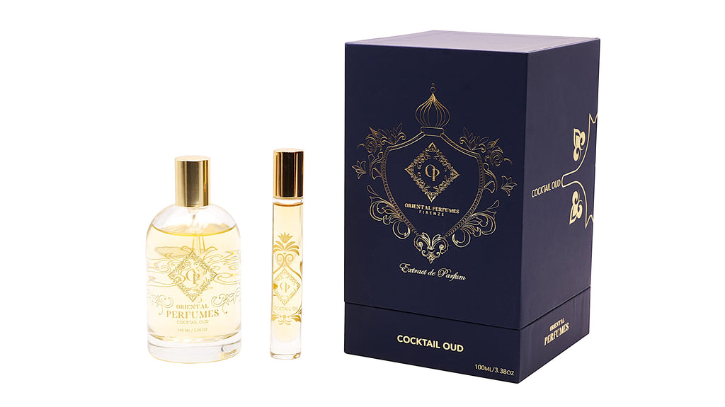 Il flacone da 100ml di Cocktail Oud accanto al sottile travel spray da viaggio e alla scatola premium blu scuro opaco con dettagli dorati di Oriental Perfumes Firenze—un esclusivo regalo di profumo ad alta concentrazione.